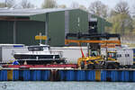 Eine Terminalzugmaschine von Terberg zieht ein gerade angeliefertes Motorboot an den Hafenkai.