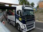 VOLVO FH700 von PORR samt Tiefladeranh�nger passiert eine mit gleichnamigen Werbetr�gern versehene Baustelle; 260909