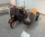 Vespa 125N mit Beiwagen aus dem Jahr 1955. Im Jahr 1946 präsentierte der Flugzeughersteller Piaggio aus Pontedera/Toskana seinen ersten Motorroller. Die Ur-Vespa hatte einen Einzylinderzweitaktmotor mit 98 cm³. Ab 1948 konnte dann auch die 125´er Vespa ausgeliefert werden. Der Einzylinderzweitaktmotor des gezeigten Rollers hat einen Hubraum von 125 cm³ und leistet zwischen 4,5 PS und 5,5 PS. Aufgrund der Montage des Seitenwagens, gehe ich davon aus, das diese Vespa in ein Land mit Linksverkehr ausgeliefert wurde. Museo Automovilistico de Malaga/Spanien am 22.03.2026.