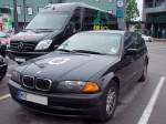 BMW 3er-combi mit kleinem Münchner-Wappen auf der Motorhaube, sowie der Tourbus von Hans Söllner stehen frühmorgens auf dem Parkplatz vor einem Hotel in Ried i.I.;100530