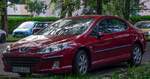 Hier ist ein roter Peugeot 407 Stufenheck zu sehen. Die Aufnahme stammt von Mai, 2024.