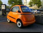 Kleinwagen Microlino in Orange abgestellt bei einer Garage in Bern am 17.08.2025