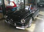 Alfa Romeo Giulia Spider der Baureihe 101. Im Juni 1962 brachte Alfa Romeo die Giulia Spider auf den Markt. Das Modell entsprach optisch fast genau dem Vorgängermodell Giulietta Spider und wurde ebenfalls bei der Carrozzeria Pininfarina montiert. Optisch kann man die Giulia Spider von der Giulietta Spider am besten an der  Lufthutze  auf der Motorhaube erkennen. Von 1962 bis 1965 wurden rund 10.350 Giulia Spider montiert. Der Vierzylinderreihenmotor hat einen Hubraum von 1570 cm³ und leistet 91 PS. Das Modell hatte damals schon serienmäßig ein Fünfganggetriebe. Classic Remise Düsseldorf am 02.03.2026.