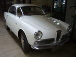 Alfa Romeo Giulietta Sprint 1300 Veloce der Seria 2 aus dem Jahr 1958. Das Modell wurde auf dem Turiner Autosalon des Jahres 1954 vorgestellt. Als der Salon nach einer Woche zu Ende ging hatten ca. 3000 Kunden eine Bestellung für ein solches Coupe unterschrieben. Das Modell wurde bis 1964 in drei Serien hergestellt. Das gezeigte Auto in der Veloce-Version und der zweiten Serie wird von einem Vierzylinderreihenmotor angetrieben, der aus einem Hubraum von 1290 cm³ eine Leistung von 90 PS an die Hinterachse weiterleitet. Die Höchstgeschwindigkeit wurde mit 180 km/h angegeben. Classic Remise Düsseldorf am 15.10.2022.