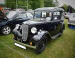 Der Austin 7 gilt als Meilenstein im britischen Automobilbau. Die Erfolgsstory begann 1922, als Herbert Austin zusammen mit Stanley Edge ein Fahrzeug entwickelte, das die britische Automobilwelt grundlegend veränderte. Der Austin 7 ersetzte Motorräder mit Beiwagen und Dreiräder als bevorzugtes Fortbewegungsmittel der Arbeiterklasse. Das kompakte Untergestell mit leichter Karosserie, die enorme Alltagstauglichkeit und ein erschwinglicher Preis machten ihn zum Auto für die breite Masse. Die weltweite Lizenzproduktion, etwa bei BMW als Dixi, bei Rosengart in Frankreich oder gar bei Nissan in Japan belegte seine Beliebtheit. Bis zur Produktionseinstellung 1939 wurden etwa 290.000 Exemplare gebaut, viele exportiert oder lizenziert. Während seiner Produktionszeit war das Modell mit insgesamt 21 Karosserie- und Motorversionen lieferbar. Hier wurde ein Austin 7  Ruby  MK2 aus dem Jahr 1934 abgelichtet. Das Modell  Ruby  wurde von 1934 bis 1937 produziert. Der Vierzylinderreihenmotor hat einen Hubraum von748 cm³ und leistet 12 PS. Classic car meeting in Abergavenny/South Wales am 25.05.2025.