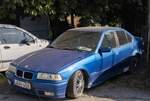 BMW 3er E36 Sedan in Blau Metallic (nicht die Farbe ab Werk), fotografiert in Juni, 2025.
