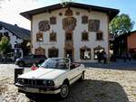 BMW 320i in Cabrio-Ausführung vor einem der wunderschön verzierten Häuser in Oberammergau; 211002