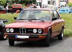 BMW E12 520 im Farbton granatrotmetallic. Das Modell E12 löste im September 1972 das Vorgängermodell BMW 2000, die so genannte, neue Klasse, ab. Ein großer Teil der technischen Komponenten blieb erhalten, während sich die Karosserie wesentlich voluminöser präsentierte. Der gezeigte 520 muss nach den Werksferien 1976 produziert worden sein, da er schon die Rückspiegel aus Kunststoff trägt. Angetrieben wird der Wagen von einem Sechszylinderreihenmotor mit einem Hubraum von 1990 cm³ und einer Leistung von 125 PS. Oldtimertreffen Flughafen Essen/Mülheim am 06.06.2022.