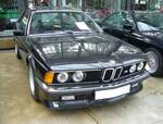 BMW E24 635CSi M6 aus dem Jahr 1985 im Farbton diamantschwarzmetallic. Das BMW 6´er Coupe der Baureihe E24 wurde im März 1976 auf dem Genfer Auto Salon vorgestellt und bis 1989 produziert. Das Coupe war mit etlichen Motorisierungen lieferbar. Spitzenmodell war jedoch der abgelichtete 635 CSi M6, der ab Frühjahr 1984 bei den Händlern stand. Äußerlich unterscheidet er sich vom  normalen 635CSi  durch eine tiefer herunter gezogene Frontschürze. Unter der Haube ist der Motor des BMW M1 verbaut. Dieser Sechszylinderreihenmotor mit Vierventiltechnik hat einen Hubraum von 3453 cm³ und leistet 286 PS. Die Höchstgeschwindigkeit wurde von BMW mit 255 km/h angegeben. Für ein solches Auto war bei seiner Markteinführung ein Kaufpreis von mindestens DM 102.050,00 fällig. Classic Remise Düsseldorf am 20.09.2023.