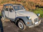 Citroen 2CV 6  Charleston Ente . Dieses Sondermodell wurde 1980 vorgestellt. Es war eine limitierte Stückzahl von 8000 Fahrzeugen geplant. Wegen der großen Nachfrage wurde das Modell aber dann doch ins Standardmodellprogramm von Citroen aufgenommen. Anfänglich wurde das Modell nur in einer rot-schwarzen Lackierung ausgeliefert. Später kam dann auch die gezeigte Farbkombination nachtgrau/kormorangrau hinzu. Neben geänderten Rückspiegeln hat dieses Sondermodell nun auch innenliegende Scheibenbremsen an den Vorderrädern. Der luftgekühlte Zweizylinderboxermotor hat einen Hubraum von 602 cm³ und leistet 29 PS. Die Höchstgeschwindigkeit wurde mit 110 km/h angegeben. Das gezeigte, rechts gelenkte,  Entlein  wurde im April 1986 erstmalig zugelassen. September 2024 auf dem Besucherparkplatz eines Pubs in Pont-Neddfechan/South Wales.