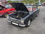 Ford Cortina MK1 GT  Crayford-Cabriolet . Der Cortina MK1 kam im Oktober 1962 auf den Markt. Am 22. Januar des Jahres 1964 stand dann der erste Cabriolet-Umbau von Crayford coachbuilding aus Westerham/Grafschaft Kent, auf der Racing Car Show in London. Ein erster großer Verkaufserfolg für dieses Crayford-Cabriolet war die Bestellung von dreißig Autos dieses Typs, die auf der Karibikinsel Bermuda als Mietwagen und Taxi eingesetzt werden sollten. In Großbritannien gab es nur einen Händler in London, der das Vertriebsrecht für die Cabriolets hatte. Bis auf den Lotus-Cortina konnten alle Modell- und Motorisierungsversionen zum Cabriolet umgebaut werden. Ein solcher GT, wie auf dem Foto, war damals ab £ 1024,00 zu bekommen. Der Vierzylinderreihenmotor hat einen Hubraum von 1498 cm³ und leistet 60 PS. Classic car meeting am 13.07.2024 in Blaenavon/South-Wales.