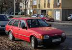Ford Escort Mk4 Turnier in rot. Foto: Dezember, 2025. Das Auto trägt Leichtmetallfelgen und ist in einem ganz schönen Zustand!