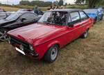 Ford Escort MK2, produziert von November 1974 bis August 1980. Im Gegensatz zum Escort MK1, wurde der MK2 nicht in England, sondern in Deutschland entwickelt. Der Wagen war als zwei- (Foto) und viert�rige Limousine, sowie als dreit�riges Kombi-Modell namens  Turnier  lieferbar. Der abgelichtete Escort ist ein 1.3L im Farbton venetian red. Der Vierzylinderreihenmotor einen Hubraum von 1297 cm� und leistet 54 PS. Treffen des Chainbridge classic car club auf der Wiese vor einem Pub in Chainbridge/Wales im Juli 2025.