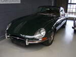Jaguar E-Type Series 1 Coupe. Der E Type, ein Klassiker par excellence im Farbton opalescent grey. Vorgestellt auf dem Genfer Salon des Jahres 1961. Wie schon 13 Jahre zuvor der XK120 stieß auch der E Type in der Fachpresse auf einhellige Begeisterung. Sowohl Cabriolet, als auch das FHC (Fixed Head Coupe) genannte, geschlossene Modell waren sofort der Traumwagen der breiten, automobilen Masse. Obwohl die Warteliste bzw. Lieferzeit lang war, bot der damalige Jaguar-Boss William Lyons den Wagen zu einem unerwartet günstigen Preis an. Der Sechszylinderreihenmotor des Series I hat einen Hubraum von 3781 cm³ und leistet 265 PS. Die Höchstgeschwindigkeit des Series I betrug 237 km/h. Classic Remise Düsseldorf am 16.12.2021.
