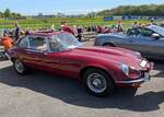 Jaguar E Type Series 3 Coupe aus dem Jahr 1971 im Farbton regency red. Produziert wurde das Modell in den Jahren von 1971 bis 1974. Vorgestellt wurde der E Type auf dem Genfer Salon des Jahres 1961. Wie schon 13 Jahre zuvor, beim Jaguar XK120, stieß auch der E Type in der Fachpresse auf einhellige Begeisterung. Sowohl Cabriolet, als auch das FHC (F ixed H ead C oupe) genannte, geschlossene Coupe-Modell waren sofort der Traumwagen der breiten, automobilen Masse. Der E Type wurde in drei Serien hergestellt. Die Serien 1 und 2 wurden von Sechszylinderreihenmotoren angetrieben. Die seit 1971 produzierte Series 3 war mit einem V12-Motor ausgerüstet, der aus einem Hubraum von 5343 cm³ 275 PS leistet. Classic car show at Chepstow race course/South Wales am 27. April 2025.