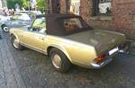 Profilansicht eines Mercedes Benz W113 (E28) 280SL in einer eleganten goldfarbenen Lackierung.