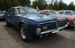 Mercury Cougar X7 aus dem Jahr 1968. Der 1964 vorgestellte Ford Mustang war ein Verkaufserfolg, insbesondere bei den jungen Menschen der Nachkriegsgeneration. Um auch älteren Kunden einen sportlichen, aber auch luxuriöseren Wagen an die Hand geben zu können, brachte die Ford-Tochter Mercury 1967 den  Cougar  auf den Markt. Der  Cougar  ist nach einem nordamerikanischen Berglöwen benannt. Das luxuriöse Sport-Coupe war in drei Varianten erhältlich. Die gezeigte X7-Baureihe war das Toppmodell. Das Auto war grundsätzlich mit V8-Motoren in der Bandbreite von 4.7 Litern bis 7.0 Litern Hubraum ausgerüstet. 11. Oldtimertreffen des AMC Duisburg auf dem Parkplatz des Landschaftspark Duisburg Nord am 24.08.2025.