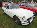 MG B GT V8, wie er von 1973 bis 1976 im Verkaufsprogramm von MG stand. Basis dieses Schrägheck-Coupes war der bereits 1962 vorgestellte MG B Roadster. Der MG B Roadster wurde bis 1980 produziert. Ab 1965 ergänzte MG das Modellprogramm mit einem Schräghec-Ccoupe namens MG B GT. Im Jahr 1973 wurde diese Coupe-Baureihe um den den B GT V8 erweitert. Als Motorisierung diente diesem Fahrzeug der kleine V8-Motor aus dem Buick F-85. Dieser  Achtender  hat einen Hubraum von 3528 cm³ und leistet ca. 140 PS. Der gezeigte Wagen im Farbton glacier white wurde im ersten Modelljahr 1973 produziert. Hog's Head Classic car meeting am 06.07.2024 in Llantillio Crosseny/South-Wales.