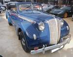 Opel Admiral in der Karosserieversion viertüriges  Cabriolet aus dem Jahr 1938. Kurz vor WW2 war bei den deutschen Autokäufern ein Hang zu großen Autos mit einem Hubraum von 3.0 Litern und mehr zu erkennen. Da die Rüsselsheimer einen ausgereiften 3.6l Motor für ihren LKW  Blitz  im Programm hatten, wurde mehr oder weniger ein Auto um den Motor herum konstruiert. Die ersten Fahrzeuge dieses Typs entstanden im Dezember 1937. Ein solches, viertüriges Cabriolet kostete bei seinem Erscheinen genau RM 7000,00. Unter der Haube verrichtet, wie schon oben beschrieben, der Sechszylinderreihenmotor aus dem Opel Blitz seine Arbeit. Der Motor hat einen Hubraum von 3626 cm³ und leistet 75 PS. 1939, mit Beginn des Krieges, war nach 2314 produzierten viertürigen Cabriolets Schluss für dieses Modell. Classic Remise Düsseldorf am 29.03.2025.