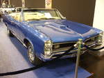 Pontiac GTO Convertible des Modelljahres 1966. Das Modell GTO war von 1964 bis 1974 eine eigenständige Modellreihe im Verkausprogramm von Pontiac. Der Wagen war als Coupe oder Convertible lieferbar. Von diesem Cabrioletmodell verkaufte Pontiac im Jahr 196612.798 Fahrzeuge zum Preis ab US$ 3425,00. Der V8-Motor hat einen Hubraum von 6361 cm³ und konnte wahlweise mit einem Doppelvergaser = 340 PS oder drei Doppelvergasern = 365 PS bestellt werden. Der abgelichtete GTO ist im Farbton fontaine blue lackiert. Essen Motor Show am 04.12.2019.