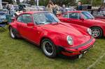 Ein rechts gelenkter Porsche 911 3.3 Turbo der Baureihe 930. In dieser Ausführung stand das damalige Toppmodell von 1977 bis 1989 im Verkaufsprospekt der Zuffenhausener. Der im Heck verbaute und gebläsegekühlte Sechszylinderboxermotor hat einen Hubraum von 3299 cm³ und leistet, mittels eines Abgas-Turboladers mit Ladeluftkühler der Marke KKK Typ 3, genau 300 PS. Die Höchstgeschwindigkeit gab das Werk damals mit 260 km/h an. Dann verarbeitete die Saugrohreinspritzung von Bosch aber auch 20 Liter Superbenzin auf 100 Kilometer. Classic car meeting in Abergavenny/South Wales am 25.05.2025.