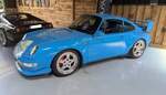 Der Porsche 911 Carrera RS von 1995, also aus der Baureihe 993, ist der letzte luftgek�hlte Rennsport-Klassiker der 911`er-Geschichte. Er wurde als reines Homologationsmodell f�r den Motorsport konzipiert, um den RSR 3.8 f�r die damalige BPR GT-Rennserie zu qualifizieren. Aufgrund seiner extremen Seltenheit und Fahrdynamik gilt er heute weltweit als eines der gesuchtesten Sammlerst�cke. Dieser Carrera RS im Farbton riviera blau wird von einem, im Heck verbauten, Sechszylinderboxermotor angetrieben. Aus einem Hubraum von 3746 cm� wird eine Leistung von 300 PS an die Hinterachse gebracht. Ausstellungsraum des Oldtimer-H�ndlers  Ignition Sheed  in Abergavenny/S�d Wales am 17.05.2025.
 