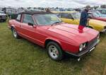 Reliant Scimitar GTC im Farbton scimitar red. Zwischen 1980 und 1986 setzte die  Sportwagenschmiede  Reliant aus Tamworth/Staffordshire insgesamt nur 442 Exemplare dieses Typs ab. Die Karosserie besteht aus leichtem Fiberglas aufgebaut auf ein Stahl-Chassis. Unter der Motorhaube werkelt ein Motor der K�lner Ford-Werke. Dieser V6-Motor hat einen Hubraum von 2792 cm� und leistet 134 PS. Das Werk gab die H�chstgeschwindigkeit des viersitzigen Cabriolets damals mit rund 185 km/h an. Der gezeigte  Scimitar  wurde 1981 erstmalig zum britischen Stra�enverkehr zugelassen. Castle Combe Vintage Show am 19.05.2024 in Wiltshire/England.