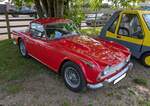 Triumph TR4A IRS, gebaut von 1965 bis 1967. Der TR4 wurde bereits 1961 vorgestellt. Im Jahr 1965 gab es einige Detailveränderungen, die Gesetzesänderungen in den USA geschuldet waren. Der Zusatz  IRS  weist darauf hin, das der Wagen mit einer unabhängigen, hinteren, Radaufhängung ausgerüstet ist. Serie war eine hintere Starrachse. Der Vierzylinderreihenmotor leistet 104 PS aus einem Hubraum von 2138 cm³. Der gezeigte Wagen im Farbton signal red ist mit einem Hardtop-Dach aus dem Zubehör ausgerüstet und wurde 1966 zum ersten mal zum britischen Straßenverkehr zugelassen. Classic car show at Chepstow race course/South Wales am 27. April 2025.