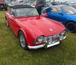 Triumph TR4 im Farbton signal red. Verglichen mit seinem legend�ren Vorg�nger TR3, bot der von Giovanni Michelotti (*1921 +1980) gezeichnete TR4, wesentlich mehr Komfort. Obwohl der TR4 �ber versenkbare Seitenscheiben, ein wesentlich besseres Verdeck und �ber einen Kofferraum verf�gte, verlor er nichts von seinen sportlichen Qualit�ten. Mit dem v�llig neuen Vierzylinderreihenmotor mit einem Hubraum von 2138 cm� und einer Leistung von 105 PS erreichte das Modell ein Leistungsniveau das sich ohne weiteres mit den Konkurrenten in dieser Kategorie messen konnte. Die H�chstgeschwindigkeit wurde mit 175 km/h angegeben. Der relativ g�nstige Preis sorgte von 1962 bis 1965 f�r ein Produktionsvolumen von rund 40.000 Fahrzeugen. Castle Combe Vintage Show am 19.05.2024 in Wiltshire/England.