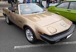 Triumph TR7 Convertible, gebaut von 1978 bis 1980. Als keilförmiges Coupe wurde der TR7 auf der Detroit Motor Show des Jahres 1975 vorgestellt. Die Convertible genannte, Cabrioletversion des TR 7 folgte drei Jahre nach der Coupe Version. Der Vierzylinderreihenmotor hat einen Hubraum von 1998 cm³ und leistet 105 PS. Der abgelichtete TR7 aus dem letzten Modelljahr 1980 ist im Farbton midas gold lackiert. Classic car meeting in Brynmawr/South Wales am 27.07.2025.