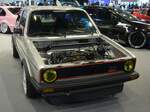 Ein etwas  aufgepimpter  VW Golf 1 MK2 GTI. Der Golf GTI Werkscode Typ 17) wurde im Jahr 1975 auf der Frankfurter IAA vorgestellt. Den GTI gab es zum Modellstart nur in den Farben marsrot und diamantsilbermetallic. Zwischen 1976 und 1983 wurden ca. 462.000 Golf 1 GTI gebaut. Die einstigen Golf GTI-Entwickler und Ingenieure hatten mit dem Absatz von maximal 5.000 GTI´s pro Jahr gerechnet. Es wurden dann durchschnittlich 57.000 GTI´s pro Jahr. Interessant war auch die Exportquote des damals schnellsten VW Golf 1. 35% aller Golf GTI gingen nach Frankreich, 18% wurden nach Italien exportiert und 13% in die Schweiz. Ein solcher GTI im Farbton diamantsilbermetallic war im Jahr 1983 ab DM 20.465,00 zu haben. Der Vierzylinderreihenmotor hatte serienmäßig einen Hubraum von 1780 cm³ mit einer Leistung von 112 PS. Nach diversen technischen Verbesserungen, dürfte dieser GTI über mehr Leistung verfügen. Essen Motorshow am 06.12.2023.