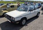 VW Golf I Cabriolet MK2 GTI im Farbton alpine white aus dem Jahr 1983. Das Cabriolet des VW Golf 1 war seinerzeit das meistverkaufte Cabrio Europas. Kein Wunder, lief das  Erdbeerkörbchen  zwischen 1979 und 1993 rund 389.000 Mal bei Karmann/Osnabrück vom Band. Dieses, rechts gelenkte, Cabriolet in der sportlichen GTI-Ausführung hat einen Vierzylinderreihenmotor mit einem Hubraum von 1781 cm³ mit einer Leistung von 112 PS. Classic car show at Chepstow race course/South Wales am 27. April 2025.