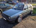Ein rechtsgelenkter, fünftüriger, VW Golf 2 GTI im Farbton jadegrünmetallic aus dem Jahr 1988.