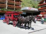 Eine der Kutschen mit denen die Hotelgste am Bahnhof von Zermatt abgeholt werden.