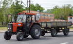 Ein Traktor URSUS 4512 aus polnischer Produktion mit Hänger am 10.05.22 in Kostrzyn (Polen).
