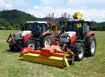 Steyr-Traktoren mit Anbaugeräten zur Heuernte, Juni 2014
