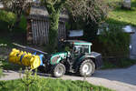 Traktor Valtra N92 mit Reck Magna Grassilageverteiler auf einem Bauernhof in Vorarlberg (2021-05-09) [Anmerkung: Der Holzschopf ist tatsächlich so schief. Auch der Baum wächst nicht gerade. Zur Untermauerung ein neuer Zuschnitt eines anderen Fotos: Man beachte die Garagenwand rechts als brauchbare Senkrechte].