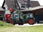 Ein Fendt mit Frontlader füllt einen Futtermischwagen am 26.06.14 in Maintal