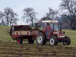 FIAT 45-66DT bringt mit dem mitgeführten Düngerstreuer Stallmist auf die herbstliche Wiese;101026