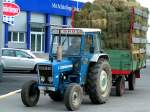 FORD4100 verl�sst mit einer ziemlich hohen Heufuhre das Lagerhaus Geinberg; 090331