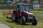 Steyr Traktor mit Heuwender, steht nahe der Haltestelle Maurach auf einem Feld.