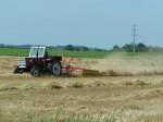 STEYR540 ist mit einem Kreiselheuer bei der Weizenstrohernte zugegen;090808