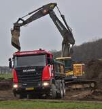 Scania G 450 Kipper, wird von einem Volvo Raupenbagger, mit Erdaushub beladen.