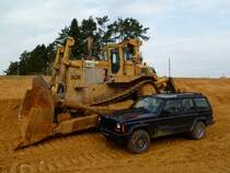 Jeep Cherokee im Größenvergleich mit einer Caterpillar D10N am 03.04.2011 auf der Autobahnbaustelle der A7 in Luxembourg