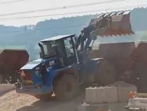 . Staubige angelegenheit, Caterpillar 938 G entlädt eine Schauffel voll Schotter in bereitgestellte Eisenbahnwagen und wirbeld dabei sehr viel Staub auf.  09.04.2015 