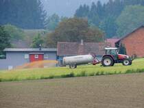 STEYR 9086 bringt mit dem mitgeführten Güllefass Dünger auf die frühlingshaften Wiesen; 150515