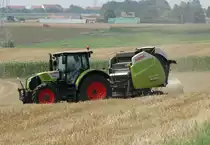 Claas Arion 550 mit einer Claas Variant 380 beim Rundballen Pressen am 28.07.14 bei Maintal