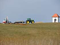 JohnDeere-6830, hat einen Kleinbagger herangeschafft; 150311