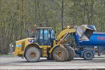 . Radlader Caterpillar 950 H hat soeben eine Schauffel mit Schotter im Satttelauflieger entleert.  Februar 2016