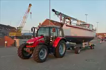 . Massey Ferguson 5610, hat einen 3 Zyl. Motor mit 3300 ccm und 105 Ps, steht am 02.05.2016 mit einem Boot auf seinem H�nger im Hafengebiet von Norddeich.
